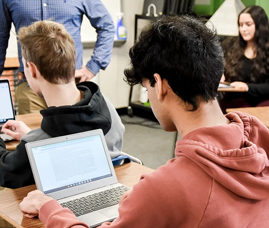 Student on computer/salmon shirt