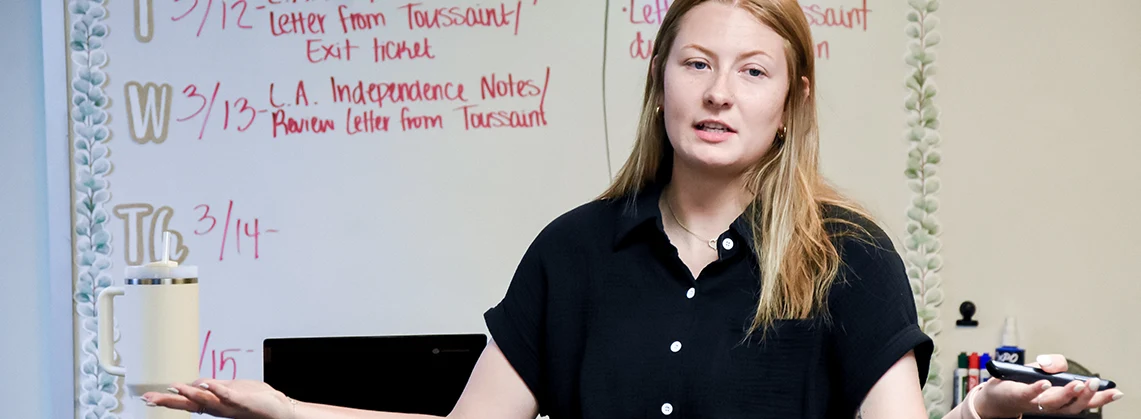 Teacher in black in front of class